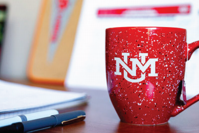 UNM coffee mug on desk